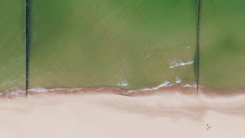 Waves crash on the shore at a beach during the afternoon sun