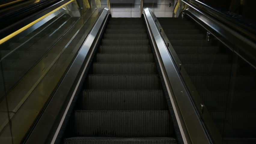 Escalator ascending inside a metro station or building interior, showing modern architecture and urban design. Smooth motion and perspective view.