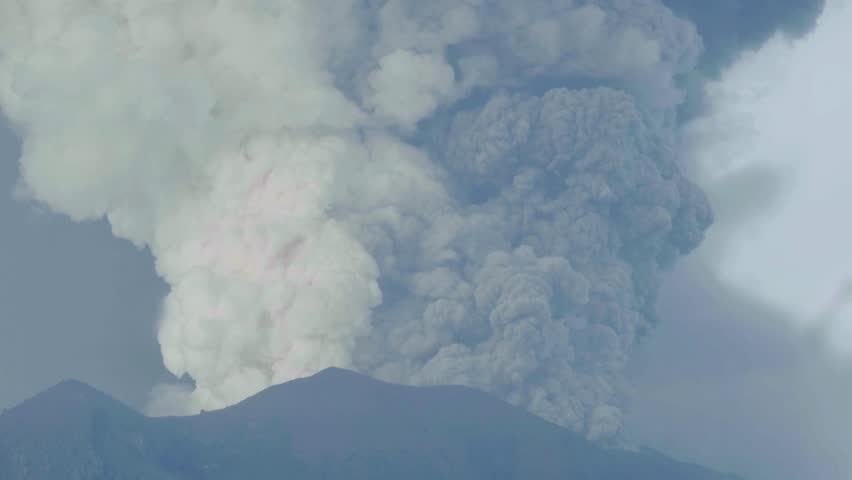 Massive volcanic eruption releases thick gray ash clouds high into the sky, illustrating the uncontrollable force of nature.