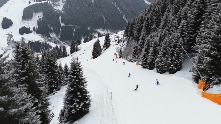 Aerial action of skiers and snowboarders racing down a snowy mountain slope in the Austrian Alps during winter vacation