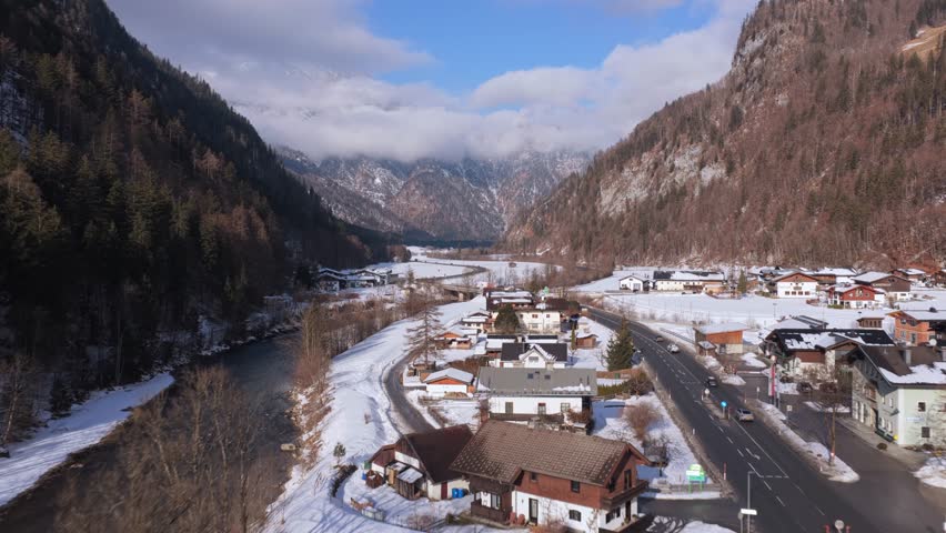 Elevated perspective over Saalbach alpine valley with snow and traffic on a sunny winter day in the Austrian Alps
