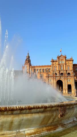 Beautiful fountain and the historic Plaza de Espana building in Seville under a clear blue sky