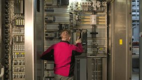 Electrical engineer inspecting industrial control cabinet and circuit breakers at factory - Powered by Shutterstock - Get 15% off with code: PIKWIZARD15