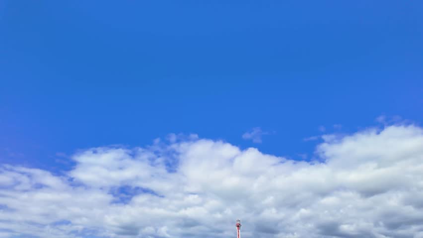 Cape Forchu Lighthouse on rocky coastline in Nova Scotia Canada with ocean waves and scenic coastal landscape captured in slow motion in the summer time with natural light and calm surroundings