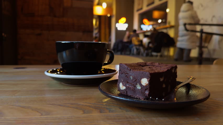Intimate cafe scene featuring chocolate dessert and brewed coffee in soft ambient light