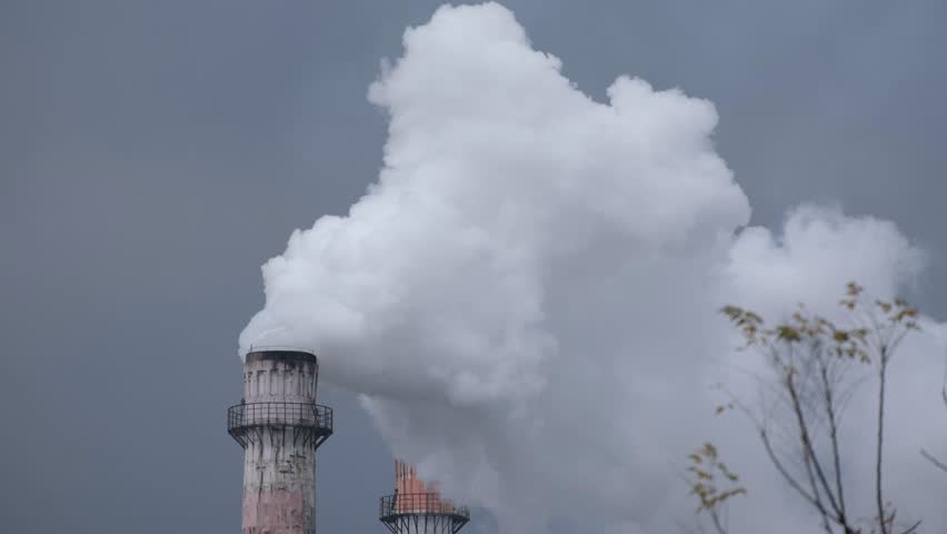 A large plume of white steam rising from an industrial smokestack at a sugar factory in Guangxi, southern China. Industrial production, energy use, manufacturing activity