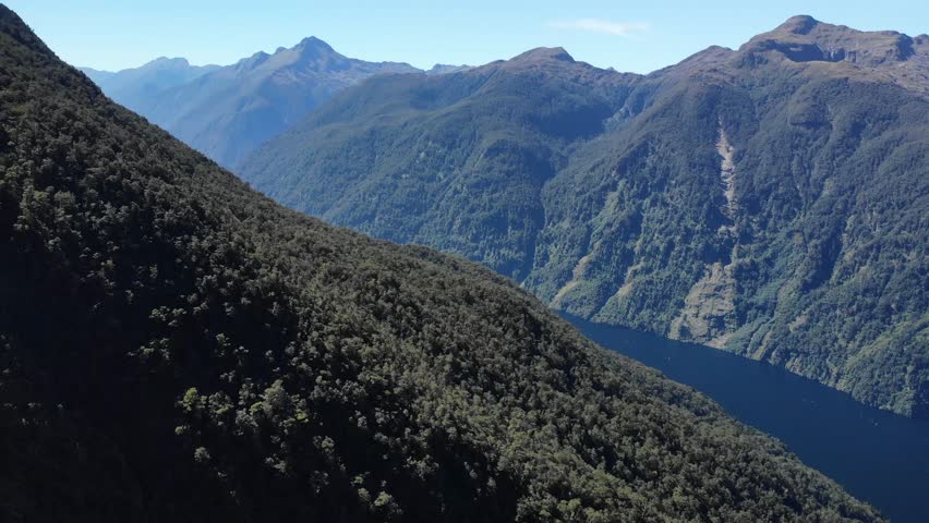 Aerial high rise reveal of Doubtful Sound in New Zealand. Fiordland National Park, landscape.