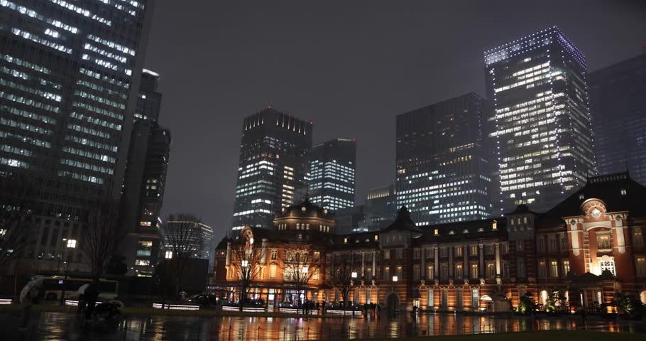 A night cityscape of the rainy urban street at the business town in Tokyo wide shot