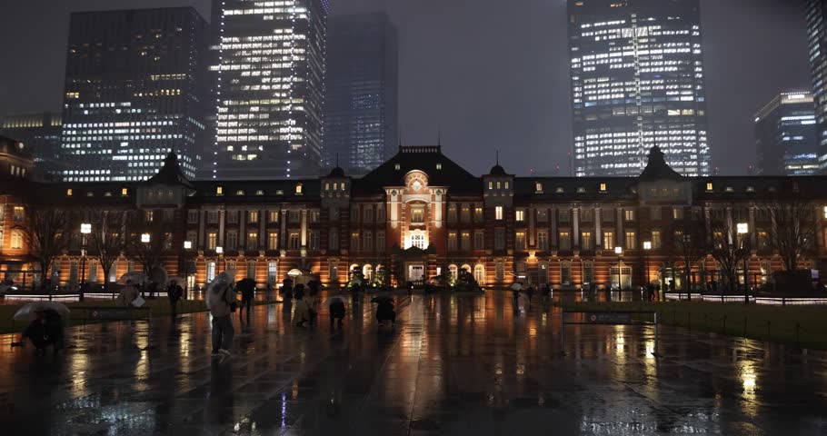A night cityscape of the rainy urban street at the business town in Tokyo wide shot