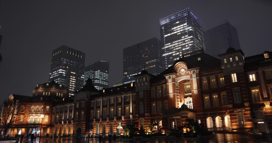 A night cityscape of the rainy urban street at the business town in Tokyo wide shot
