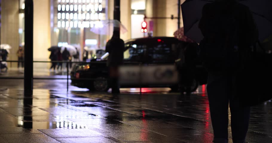 A night cityscape of the rainy urban street at the business town in Tokyo