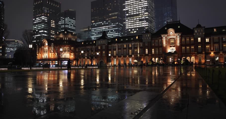 A night cityscape of the rainy urban street at the business town in Tokyo wide shot
