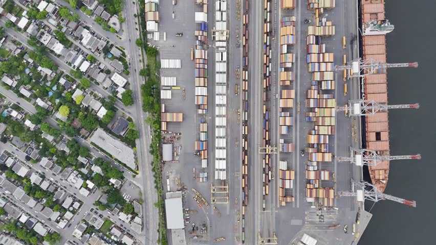 Aerial view of Montreal port with cargo containers, cranes and city skyline at sunset. g.