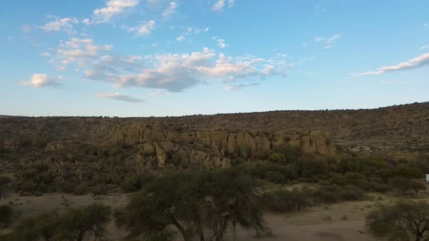 Stunning view of rock formations and clouds in a desert landscape during sunset in a remote area