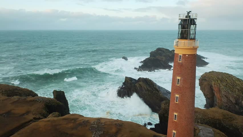 Ascending drone shot of the Lighthouse in Ness on a stormy day.
