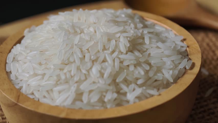 close-up of rice grains in a wooden bowl.