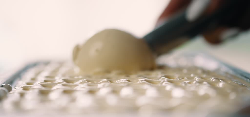 Close-up of creamy vanilla ice cream scooped in a bowl, showcasing texture, freshness, and indulgent dessert appeal.