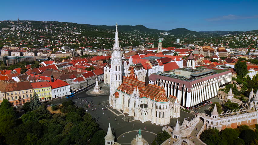 A detailed architectural shot of the historic Matthias Church in the Heart of the Buda Castle District, showcasing its iconic diamond-patterned Zsolnay tile roof and intricate neo-Gothic spires.