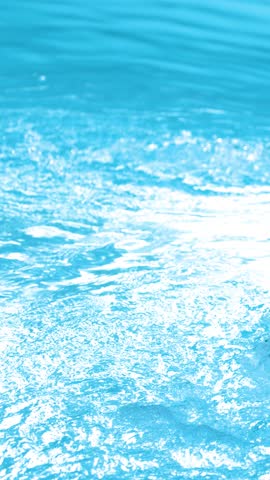 Clear blue water splashes and bubbles as it circulates through a pool jet filter system