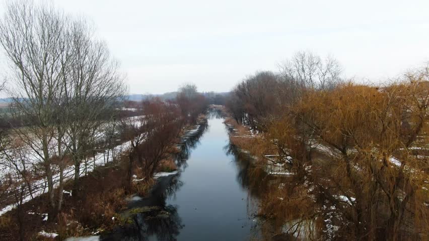 Danube Valley Main Canal flowing between banks with bare trees in Nemesnádudvar, Hungary