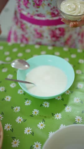 Woman preparing a cream, adding mayonnaise and lemon