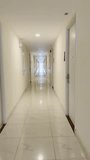 Handheld vertical footage presents a slow first-person walk through an unusually long, luminous white corridor that evokes a premium hotel, modern apartment complex, or high-end commercial residence. The polished marble-look floor reflects overhead lighting and powerful daylight streaming from a floor-to-ceiling window at the far end, creating a striking vanishing-point perspective and elegant bands of light across the surface.

Crisp white walls, identical doors with electronic locks and peepholes, visible room numbers, security cameras, fire-safety features, and glowing green exit signs reinforce impressions of cleanliness, order, and contemporary design standards. The steady forward movement allows architecture, symmetry, and depth to guide the viewer’s eye naturally toward the distant window, emphasizing clarity, precision, and modern spatial planning.

Visually, the shot communicates reliability, calm, and premium living. It is highly adaptable for real-estate marketing, luxury property showcases, hotel branding, hospitality presentations, corporate safety videos, and smart-building promotions. It also functions effectively as a cinematic transition, minimalist motion backdrop, or vertical-screen visual for apps, digital displays, social media, and architectural storytelling centered on modernity, security, and forward movement. - Powered by Shutterstock - Get 15% off with code: PIKWIZARD15