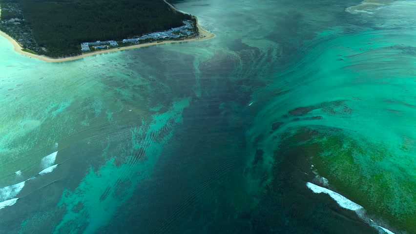 Breathtaking drone footage of the underwater waterfall phenomenon at Le Morne Brabant, where sand and silt runoff create a dramatic optical illusion in turquoise waters.