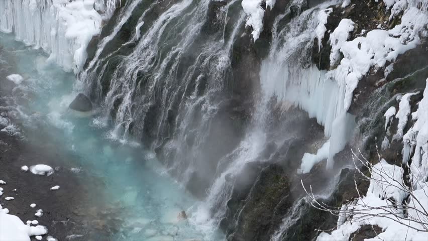 Dramatic View of Shirahige Frozen Waterfall and Mist over Blue Biei River in Winter, Hokkaido