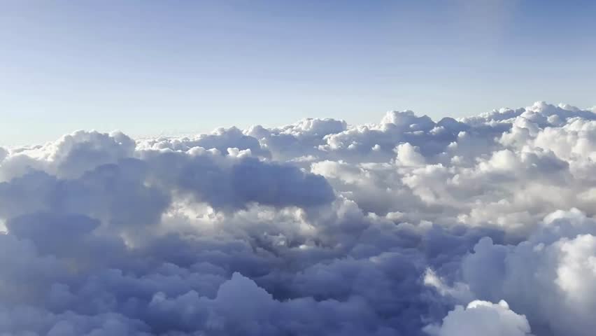 Aerial footage of vast cloudy landscape under clear blue sky