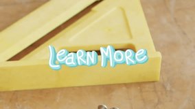 Animation of learn more text over tools on worktop. Global social media and workshop concept digitally generated video. - Powered by Shutterstock - Get 15% off with code: PIKWIZARD15