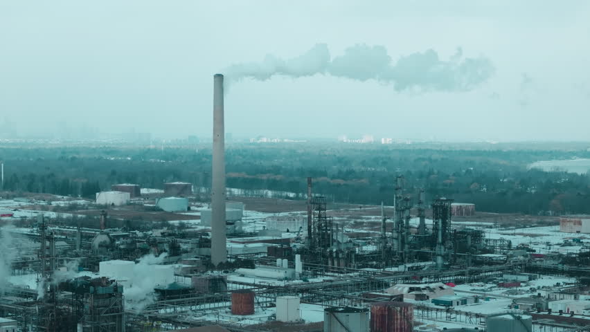 Industrial plant with smokestacks in snowy Canada cityscape