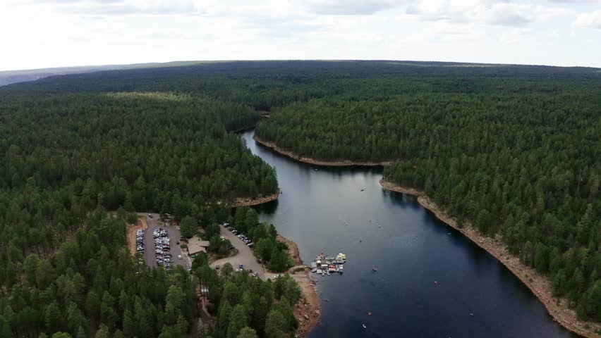 Drone shot pulling away from the Woods Canon Lake campground in Arizona's dense forest.