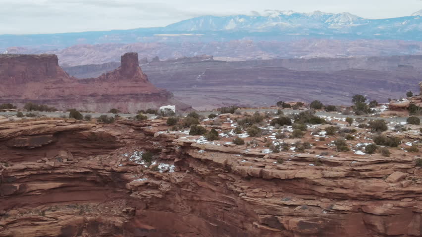 A camper RV drives along a narrow ridge road near Moab and Canyonlands, Utah.