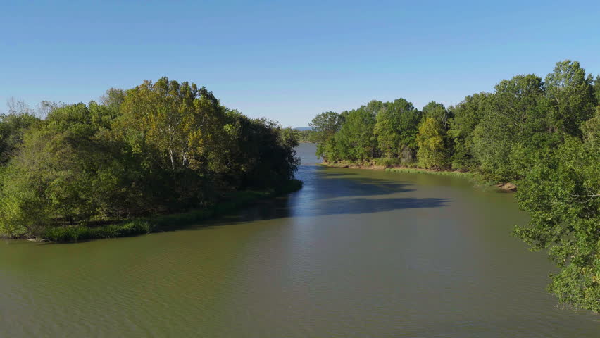 Winding section of Arkansas River bordered by dense autumn trees Cane Creek Recreation Area Arkansas, aerial medium pullback