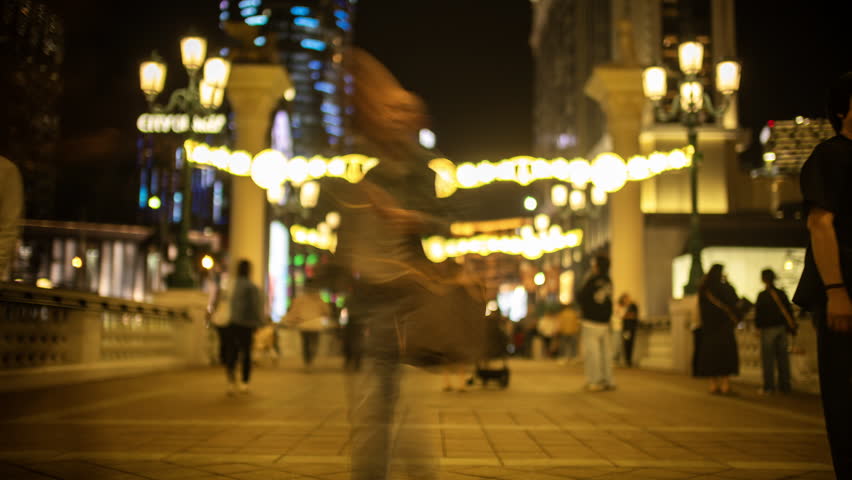  crowds of blurred people walking past the amazing skyline of macau