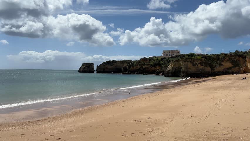 Coastline around Lagos showing sea, sandy beaches and golden cliffs with rock formations along Algarve coast in Atlantic Ocean.
