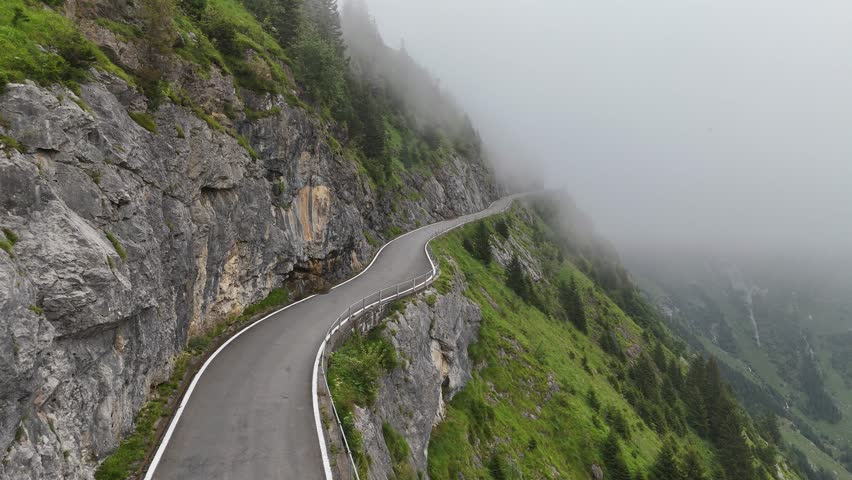 Fog at dangerous Klausenpass pass road drone video at Unterschächen, Schächental valley, canton Uri, Swiss Alps Switzerland