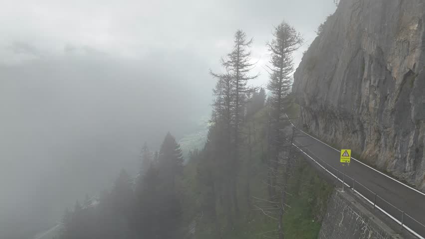 Klausenpass pass road drone video on a foggy summer day at Unterschächen, Schächental valley, canton Uri, Swiss Alps Switzerland