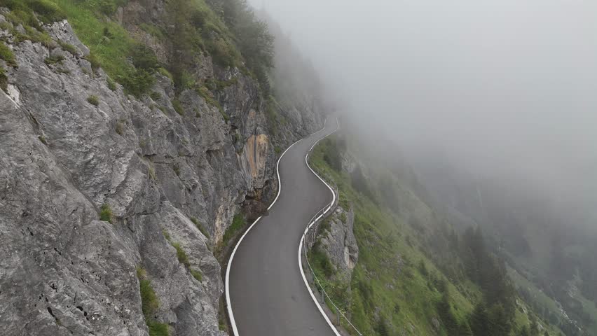 Dangerous Klausenpass pass road with fog drone video at Unterschächen, Schächental valley, canton Uri, Swiss Alps Switzerland