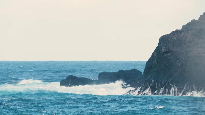 Stormy ocean waves crashing against rocky coastline