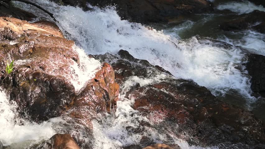 Sunlit Torrent Over Red Rocks, Rushing Water Carving Rugged Stone Ledges, Bright Highlights On Wet Surfaces, White Spray And Dynamic Motion In Mountain Creek, Adventurous Outdoor Energy