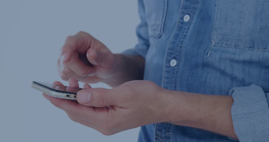 Pair of hands holding smartphone, right finger tapping and swiping while revealing live data HUD. Analytics, mobile, dashboard, overlay, globe, denim, studio