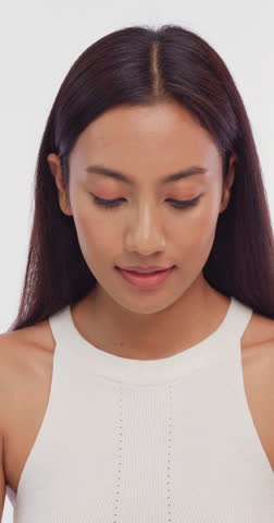 Vertical clip. Portrait of a young Asian girl with light makeup and perfect skin. Beautiful face of young woman with natural skin.