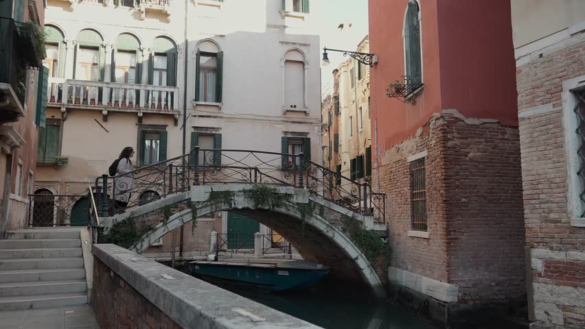 Tourist Crossing Small Bridge Over Canal in Venice