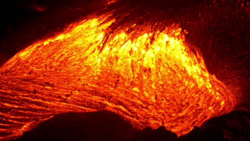 During daylight hours in Hawaii Volcanoes National Park, vibrant orange lava dramatically flows. This molten rock, spewing forth from the earth, puts on a powerful and awe-inspiring display of nature