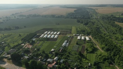Wide Aerial Rotation above Greenhouses Fields