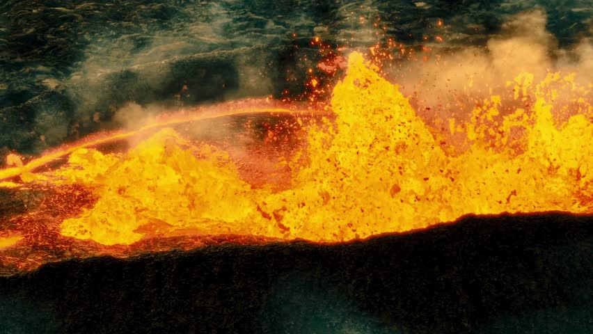 Lava erupts and flows from Kilauea Volcano into the ocean. Hot magma bubbles and steam rises on a sunny day in Hawaii Volcanoes National Park. Shows nature