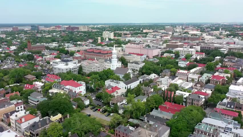 Aerial view of Charleston, South Carolina cityscape with church steeples and rooftops, highlighting historic architecture and charming streets.
