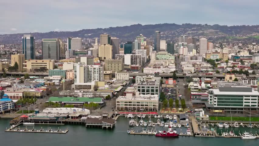 Aerial view of Oakland, California skyline and harbor on a cloudy day, highlighting urban landscape, waterfront, and cityscape details.