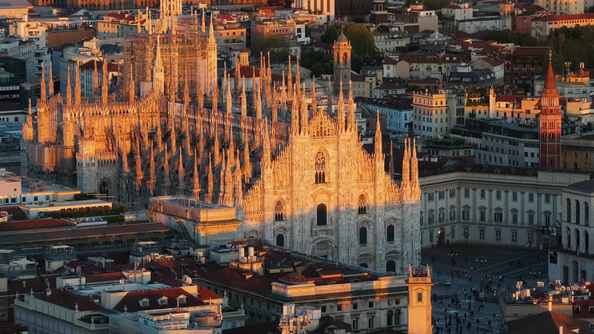 Aerial view of milan cathedral during a beautiful sunset, capturing gothic architecture and city skyline in motion